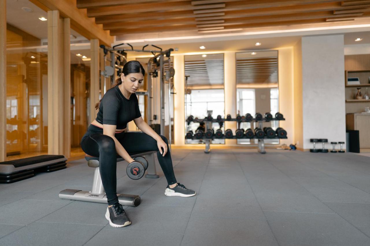 Hyatt Regency Ahmedabad Hotel Bagian luar foto A woman lifting weights